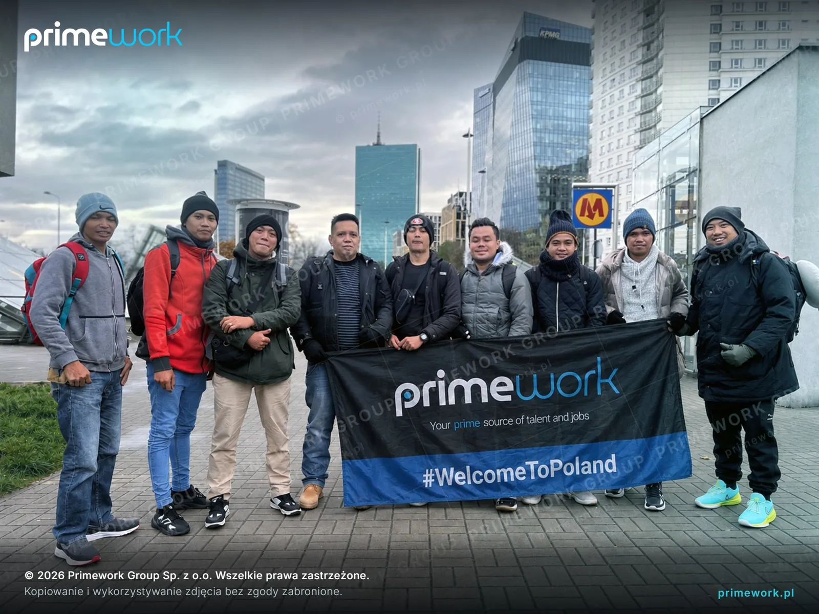 A group of Asian workers with a Primework #WelcomeToCroatia banner in central Zagreb