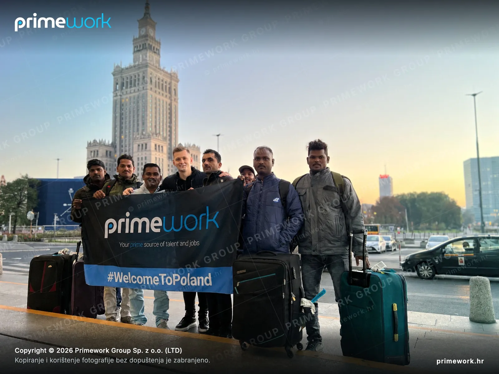 Strani radnici s Primework banerom kod Palate kulture u Varšavi