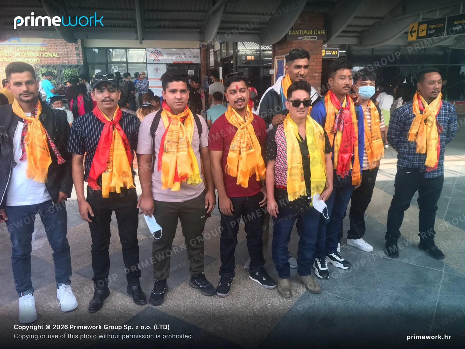 Workers from Nepal wearing traditional scarves before departure