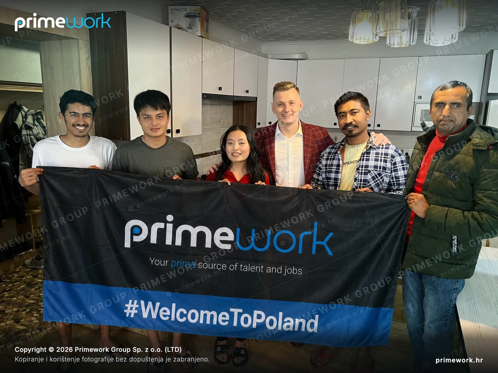 Tim stranih radnika s Primework banerom u profesionalnoj kuhinji